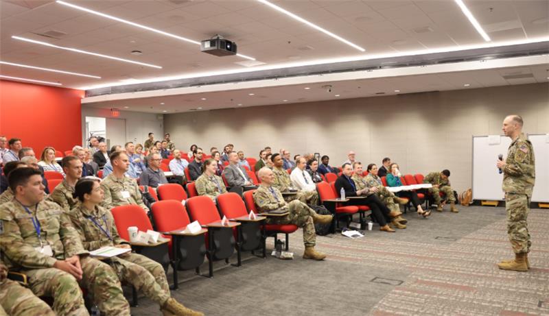 Photo of military personnel attending an event in a small theater room.